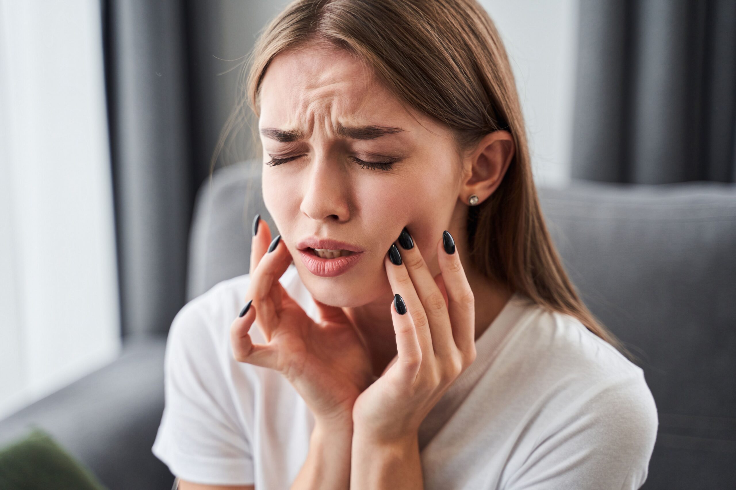Woman at home experiencing tooth pain
