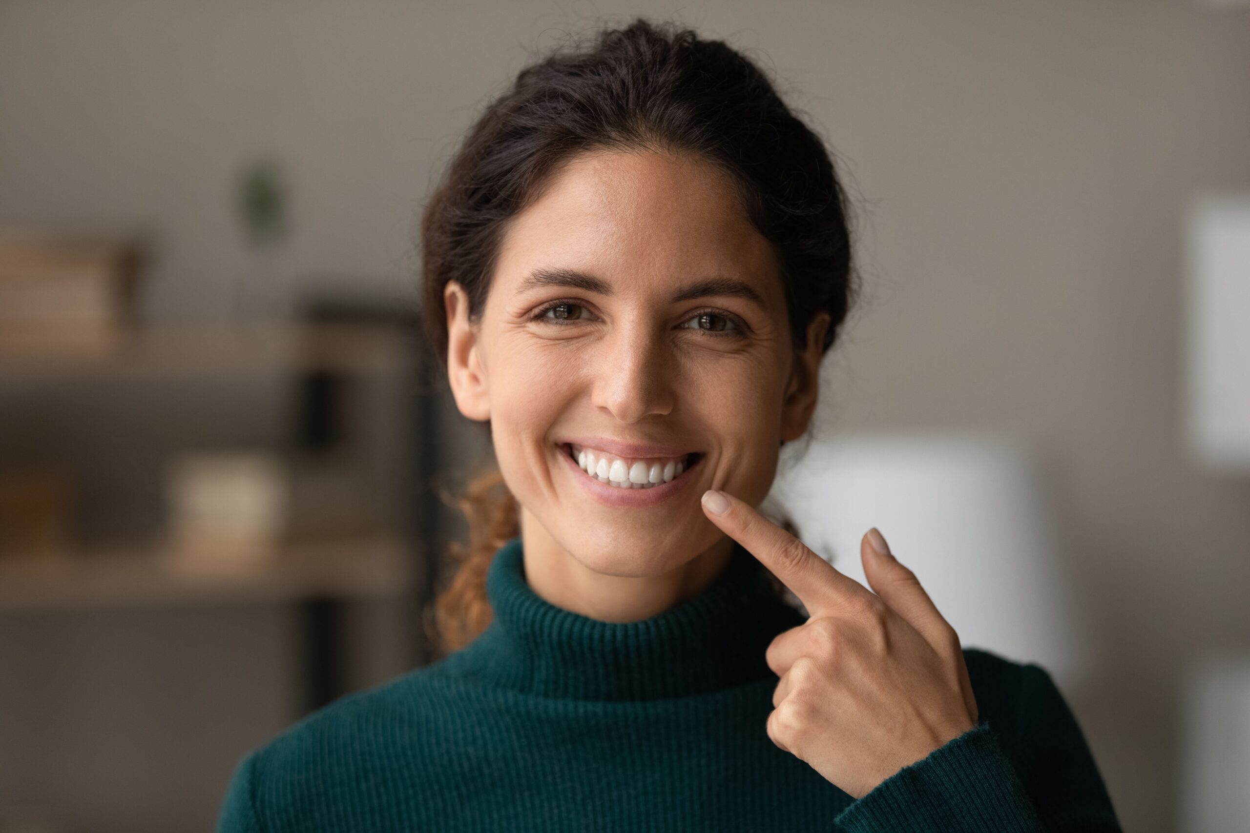 Woman pointing to her bright healthy smile