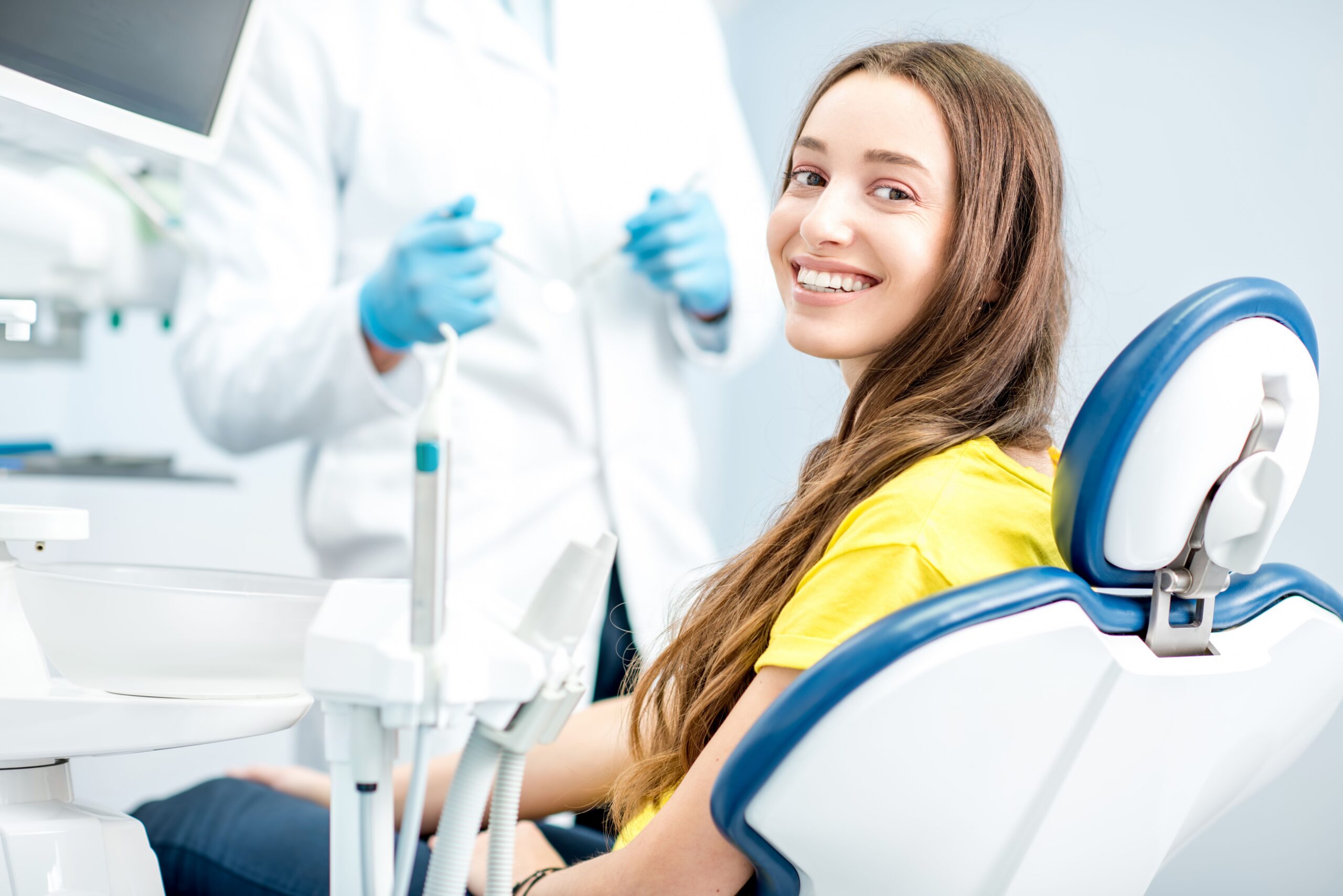 Young woman smiling in a modern dental chair